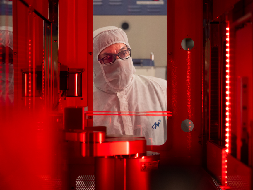 技術人員在觀察晶片製造程序，周圍發著紅光