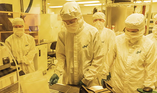 Adults wearing micron smocks working in a lab environment