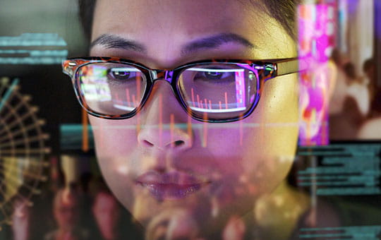 戴眼鏡女子注視著顯示演算法的電腦螢幕